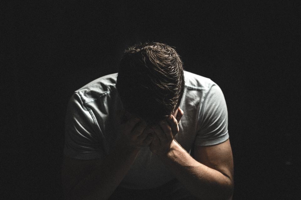 Worried man with his head in his hands